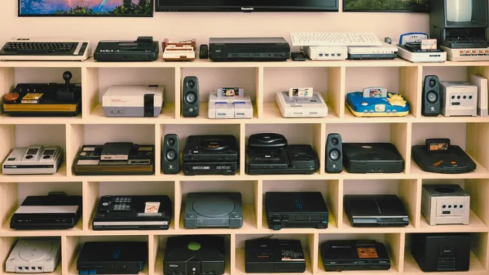 Shelves of retro and modern video game consoles in a collector’s game room